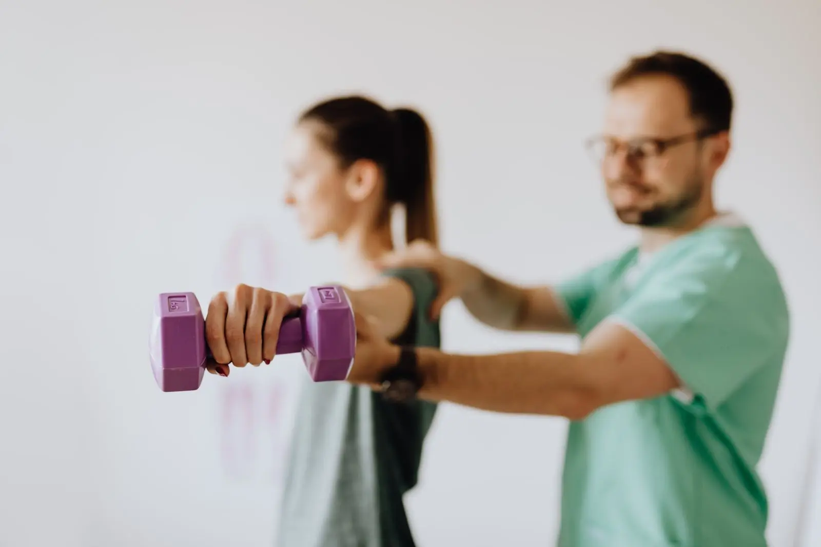 Patiente réalisant un exercice de renforcement guidé par un professionnel