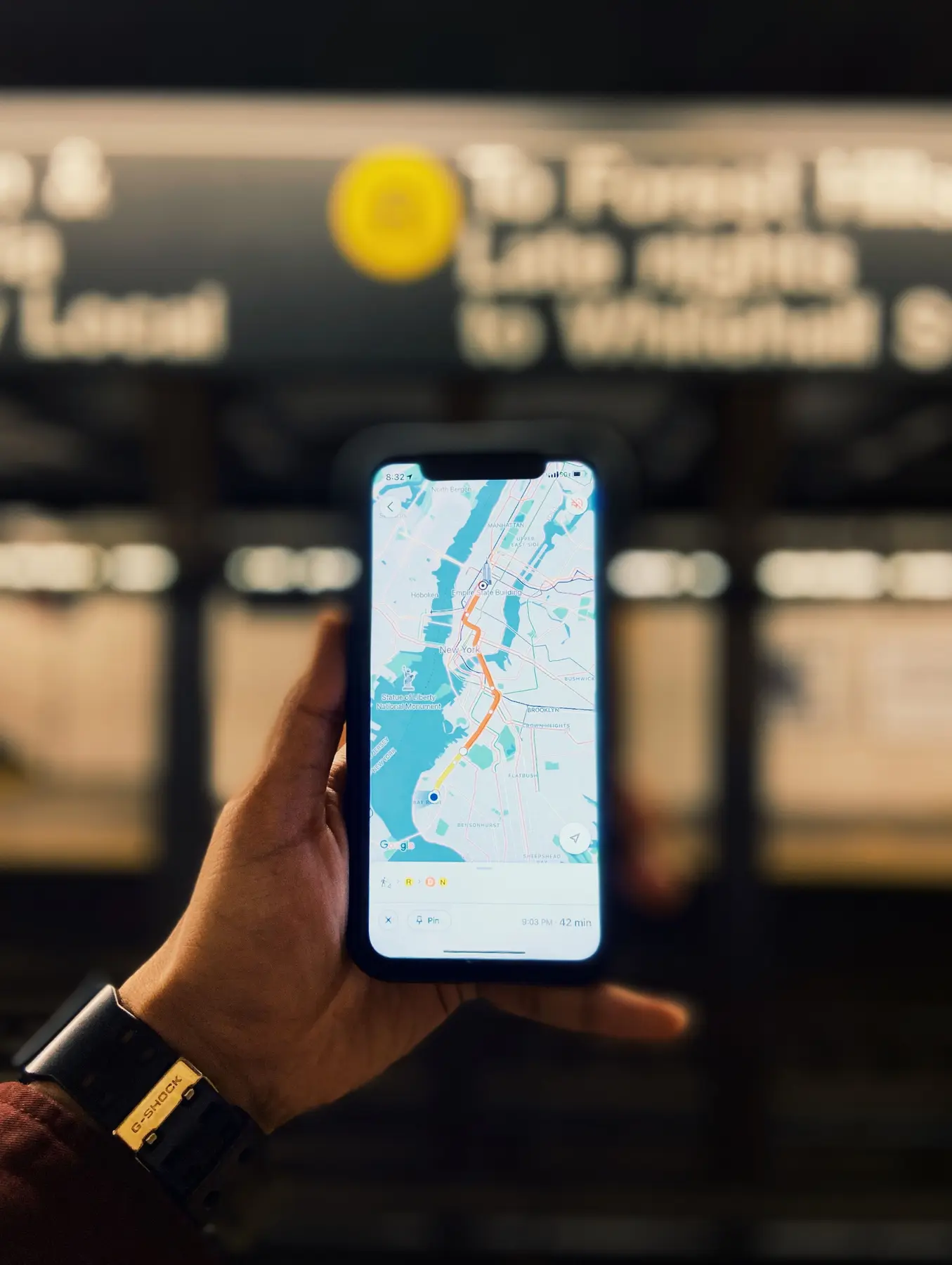 Une main tient un téléphone affichant une carte de navigation en ville